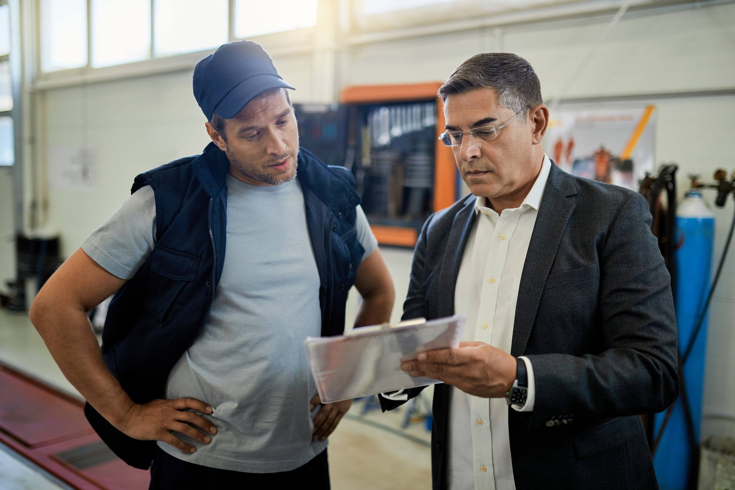 Dos personas revisando un documento en planta